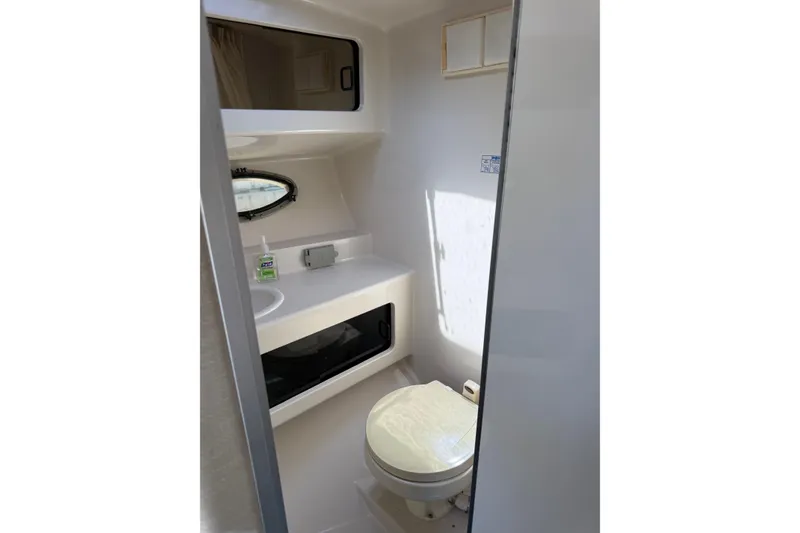 Slide: The Image of 1995 Chaparral Signature 310 boat bathroom interior with toilet and sink. - 24