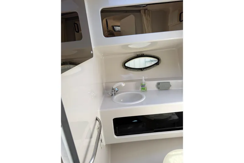 Slide: The Image of Interior of 1995 Chaparral Signature 310 boat bathroom with sink and porthole window. - 25