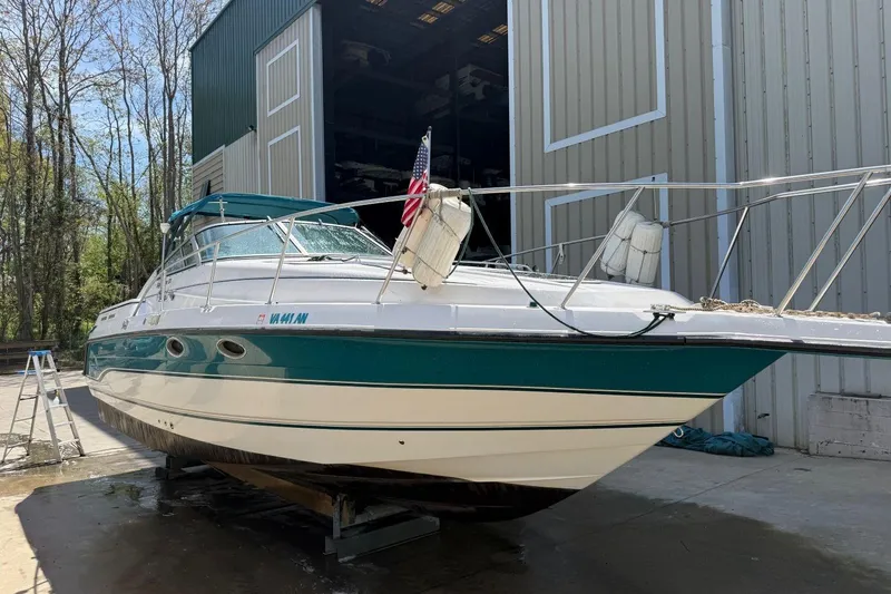 Slide: The Image of 1995 Chaparral Signature 310 boat docked near a large storage building. - 5