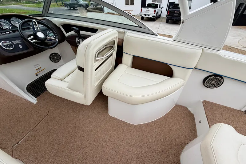 Slide: The Image of Interior of a 2014 Cobalt 24SD WSS boat with white seating and dashboard. - 10