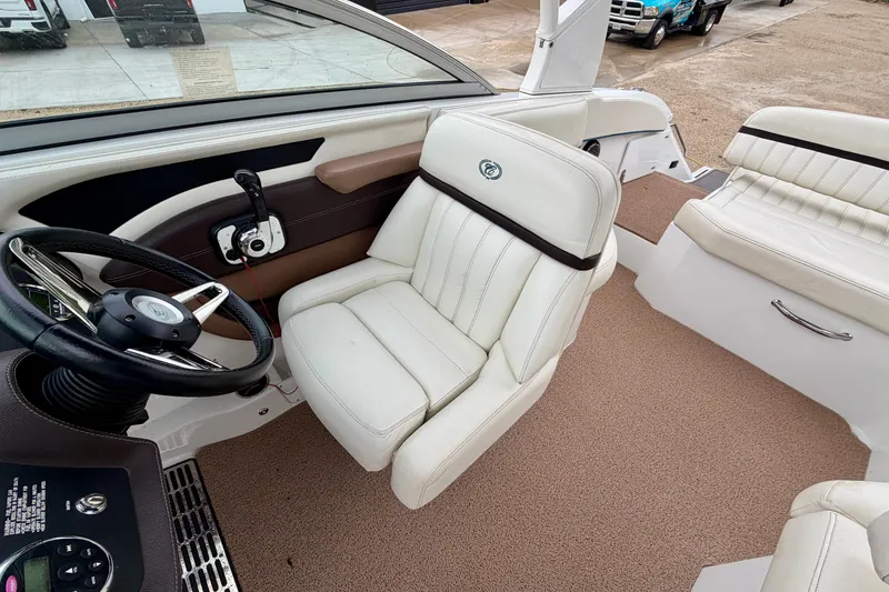 Slide: The Image of Interior of a 2014 Cobalt 24SD WSS boat with white leather seating and steering wheel. - 11