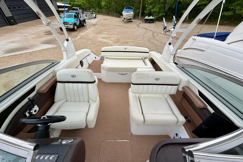 Slide: The Image of 2014 Cobalt 24SD WSS boat interior with white seating and steering wheel. - 20