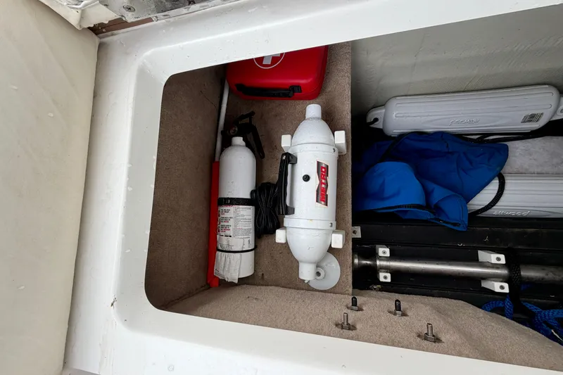 Slide: The Image of Storage compartment in a 2014 Cobalt 24SD WSS boat with safety equipment. - 22