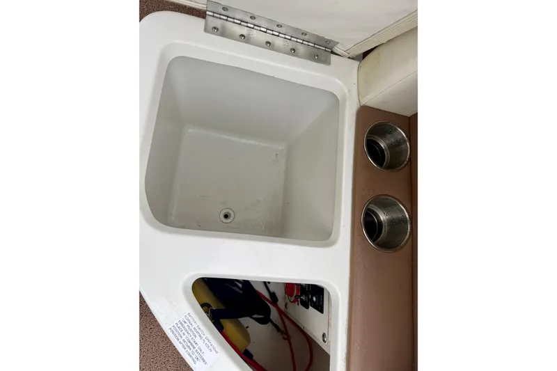 Slide: The Image of 2014 Cobalt 24SD WSS boat compartment with cup holders and storage area. - 23