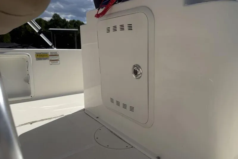 Slide: The Image of 2021 Sea Born FX21 Bay boat interior with storage compartment and safety labels. - 19