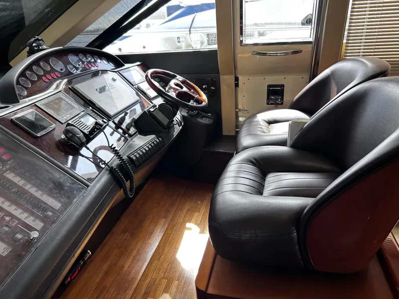 Slide: The Image of 2006 Viking Princess 61 Flybridge helm with leather seats and advanced navigation controls. - 21