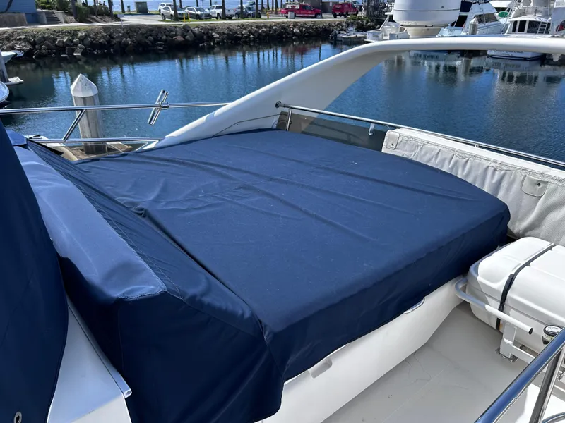 Slide: The Image of 2006 Viking Princess 61 Flybridge yacht with blue cover, docked in marina. - 29