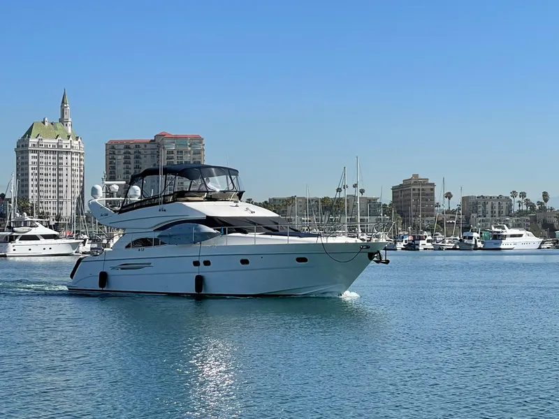 Slide: The Image of Viking Princess 61 Flybridge yacht cruising in a marina, 2006 model, with cityscape background. - 3