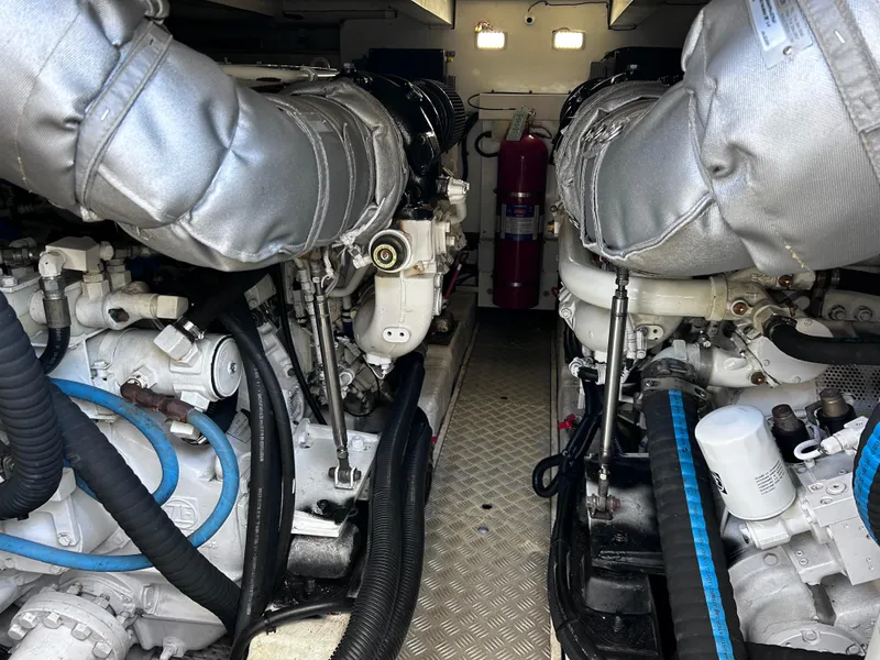 Slide: The Image of Engine room of 2006 Viking Princess 61 Flybridge yacht, featuring dual engines and fire extinguisher. - 35