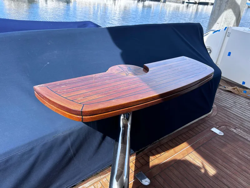 Slide: The Image of Wooden table on 2006 Viking Princess 61 Flybridge yacht, docked by the water. - 6