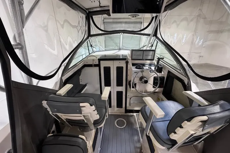 The Image of 1997 Grady-White Seafarer 228 boat cockpit with steering wheel and seating. - 3