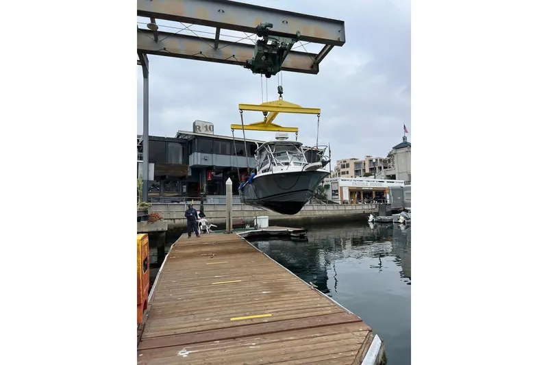 Slide: The Image of 1997 Grady-White Seafarer 228 boat being lifted at a marina dock. - 34