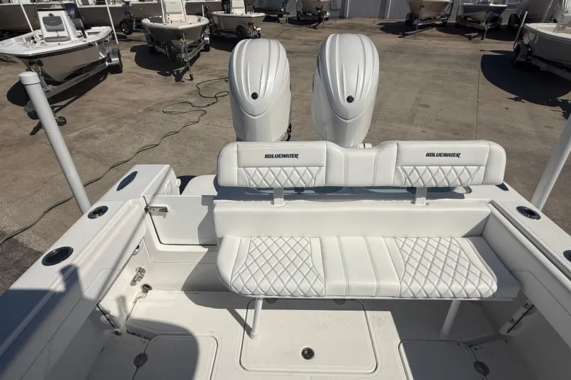 Slide: The Image of 2025 Bluewater 25t boat with dual engines and white seating in a marina. - 10