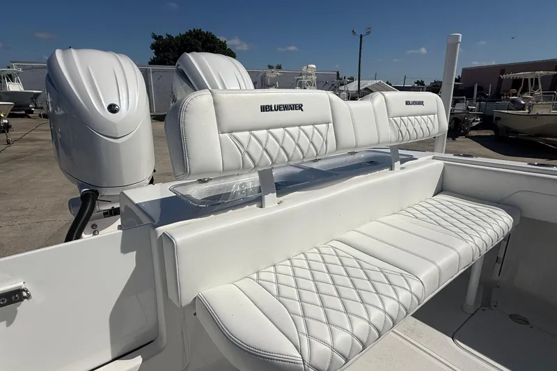 Slide: The Image of 2025 Bluewater 25t boat with white cushioned seating and dual engines. - 13