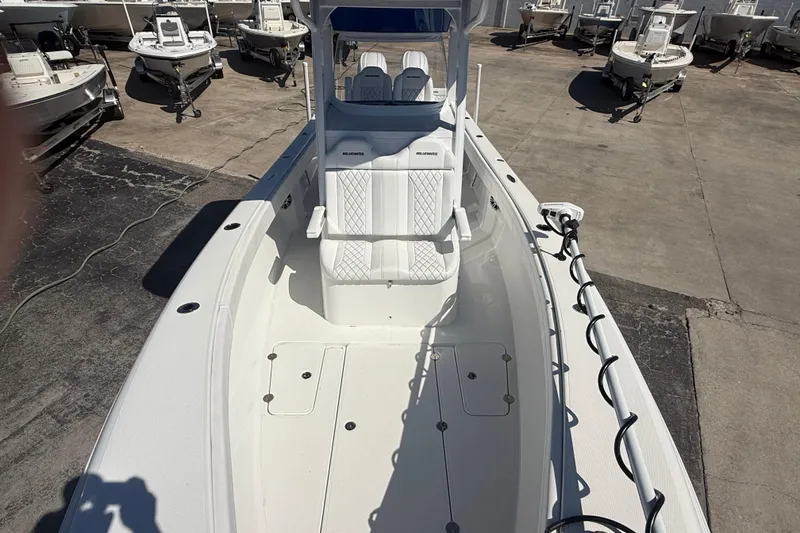 Slide: The Image of 2025 Bluewater 25t boat with white seating and spacious deck, parked in a marina. - 23