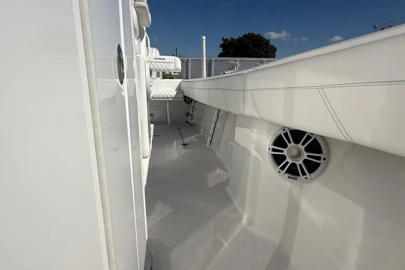 Slide: The Image of 2025 Bluewater 25t boat deck with white seating and speaker, under clear blue sky. - 24