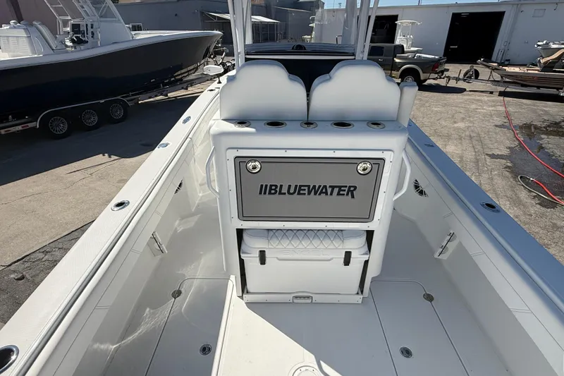 Slide: The Image of 2025 Bluewater 25t boat interior with seating and storage, docked outdoors. - 9