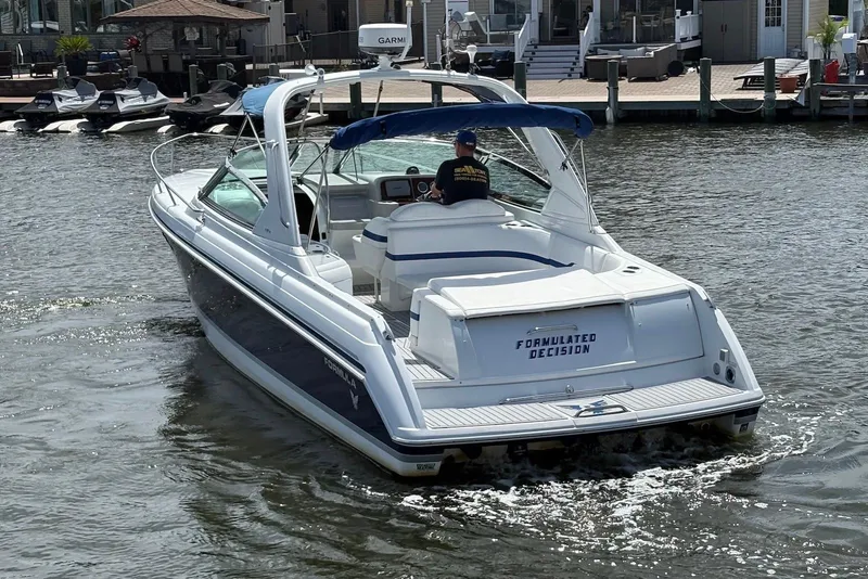 Slide: The Image of 2004 Formula 330 Sun Sport boat cruising on a calm waterway near docks. - 3