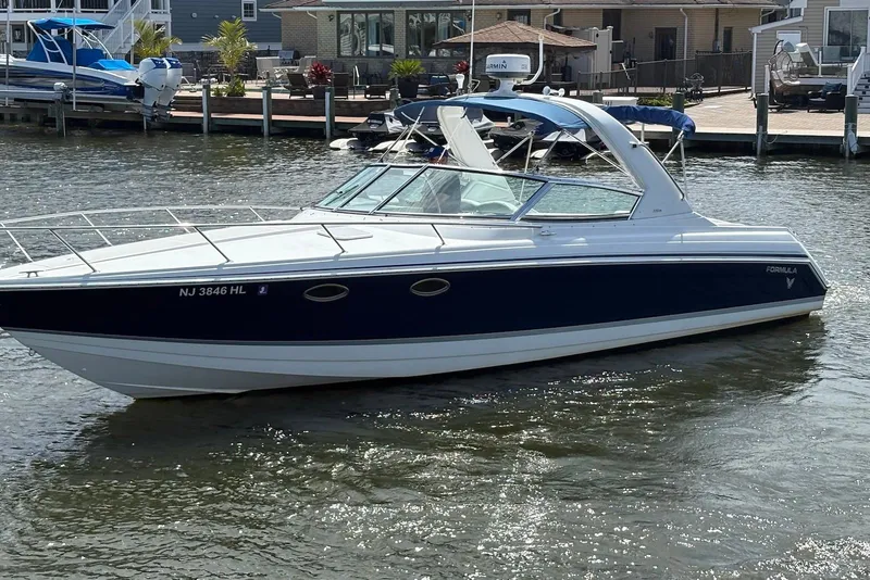 Slide: The Image of 2004 Formula 330 Sun Sport boat cruising on a sunny day near docks. - 5