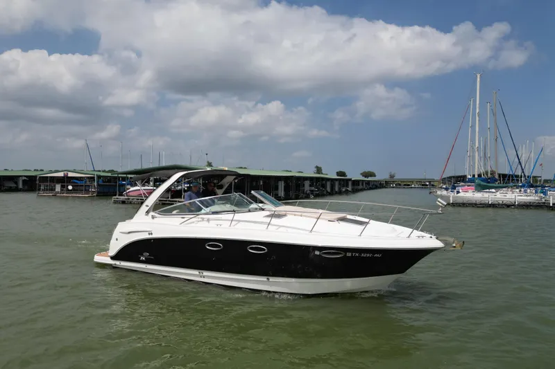 The Image of 2006 Chaparral 330 Signature boat cruising near marina under cloudy sky. - 0