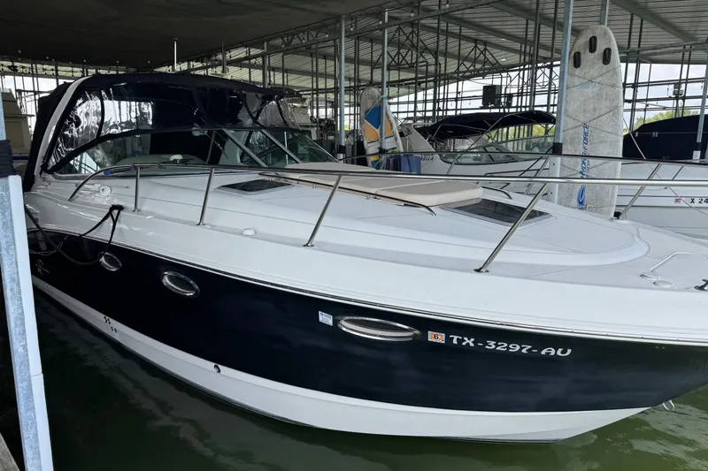 Slide: The Image of 2006 Chaparral 330 Signature boat docked in a marina, featuring sleek design and black hull. - 11
