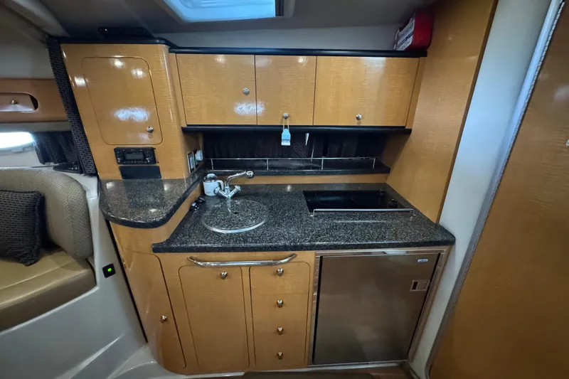 Slide: The Image of 2006 Chaparral 330 Signature yacht kitchen with wood cabinets and granite countertops. - 29