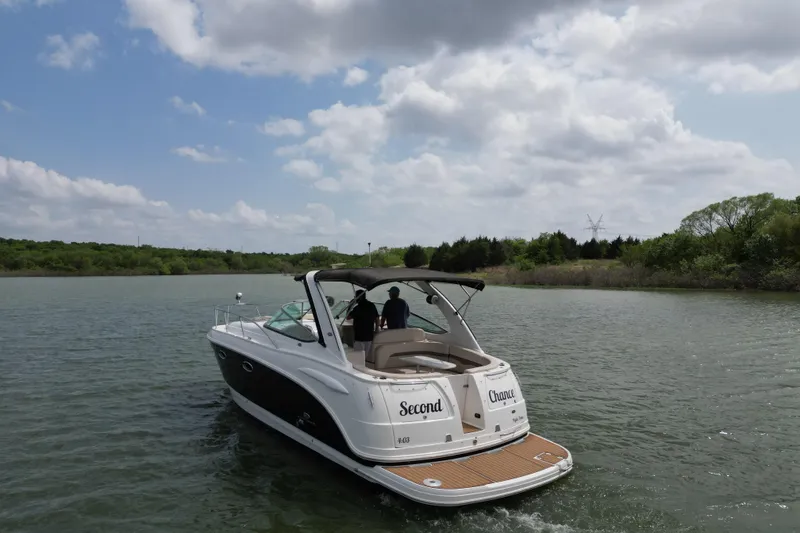 Slide: The Image of 2006 Chaparral 330 Signature boat cruising on a scenic lake under a cloudy sky. - 4