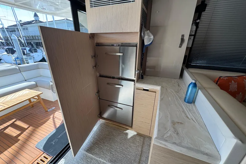 Slide: The Image of Interior of 2020 Beneteau Monte Carlo 52 yacht, featuring modern kitchen appliances and seating area. - 14