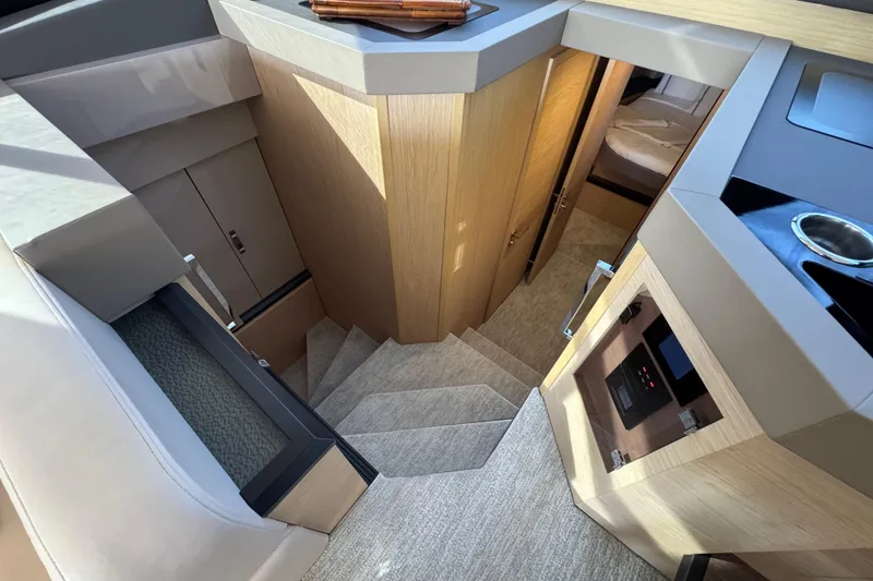 Slide: The Image of Interior view of 2020 Beneteau Monte Carlo 52 yacht, featuring modern wood finishes and stairs. - 25