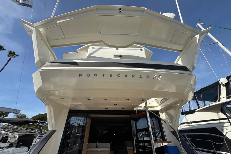 Slide: The Image of 2020 Beneteau Monte Carlo 52 yacht, rear view, showcasing elegant design and spacious deck. - 6