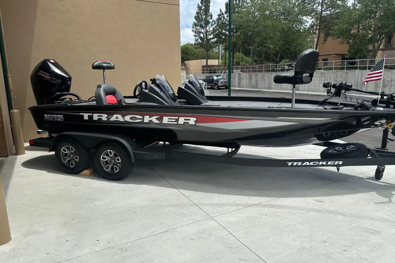The Image of 2025 Tracker Savage 215 boat on trailer, parked outdoors with American flag. - 0