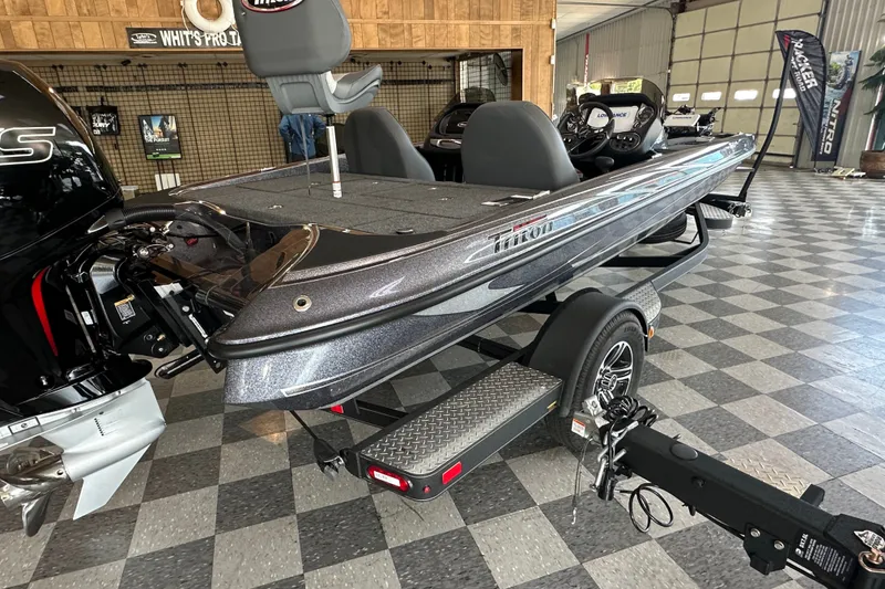 Slide: The Image of 2024 Triton 18 TrX bass boat displayed indoors on a checkered floor. - 7