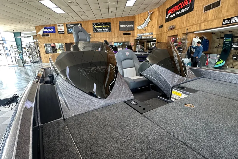 Slide: The Image of 2024 Triton 18 TrX boat displayed in a showroom with fishing gear and accessories. - 10