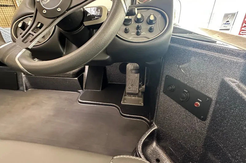 Slide: The Image of 2024 Triton 18 TrX boat dashboard with steering wheel and control panel. - 13