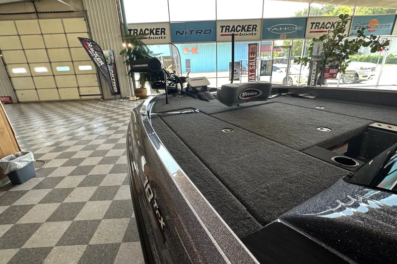 Slide: The Image of 2024 Triton 18 TrX boat displayed in showroom with fishing equipment. - 53