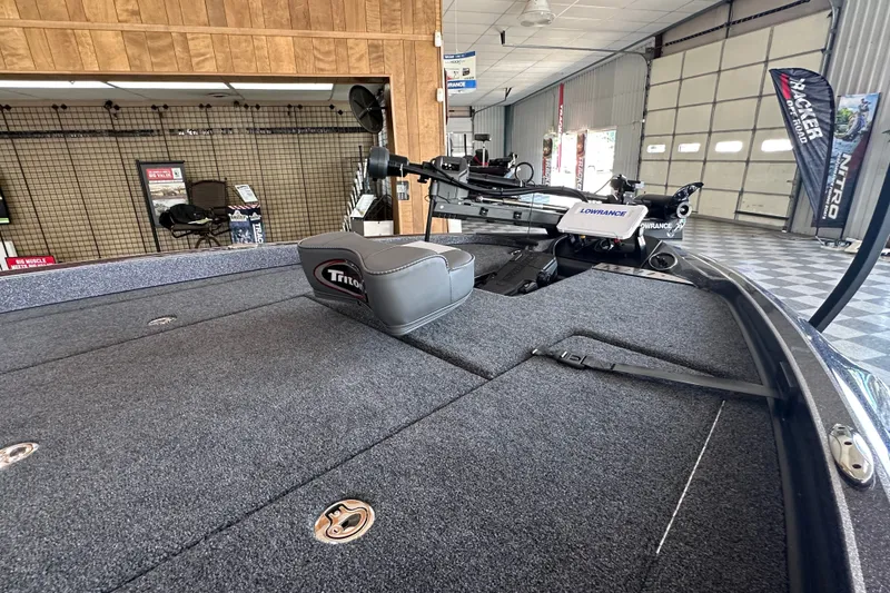 Slide: The Image of 2024 Triton 18 TrX boat interior with Lowrance equipment in showroom setting. - 9