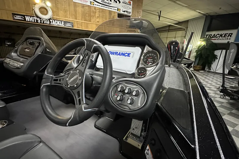 Slide: The Image of 2025 Triton 19 TrX Patriot boat dashboard with steering wheel and control panel. - 72