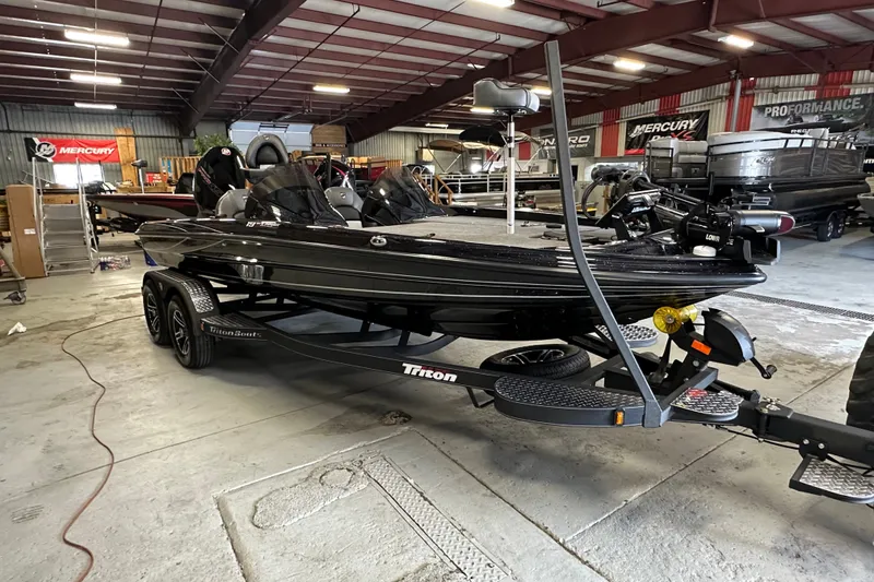 Slide: The Image of 2025 Triton 19 TrX Patriot boat in showroom, black exterior, on trailer. - 4