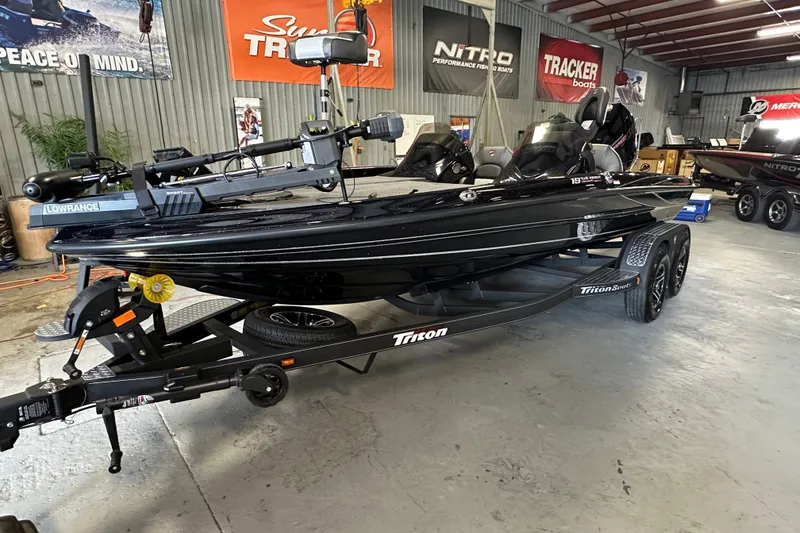 Slide: The Image of 2025 Triton 19 TrX Patriot boat in showroom, featuring sleek black design and advanced equipment. - 8