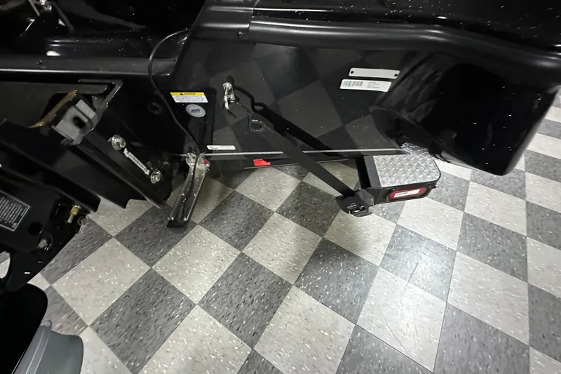 Slide: The Image of 2025 Triton 19 TrX Patriot boat trailer hitch on checkered floor. - 70