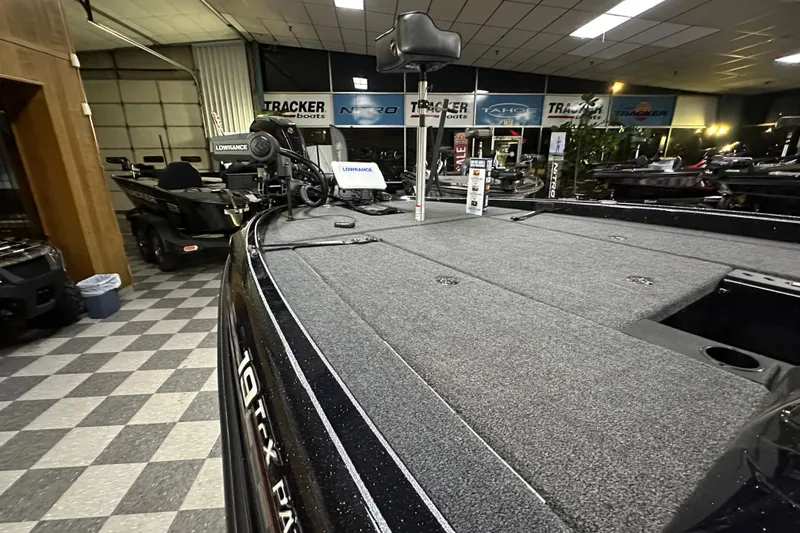 Slide: The Image of 2025 Triton 19 TrX Patriot boat interior in showroom, featuring Lowrance equipment. - 67