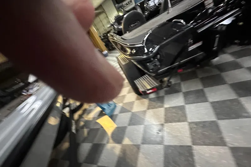 Slide: The Image of 2025 Triton 19 TrX Patriot boat in showroom with checkered floor. - 63