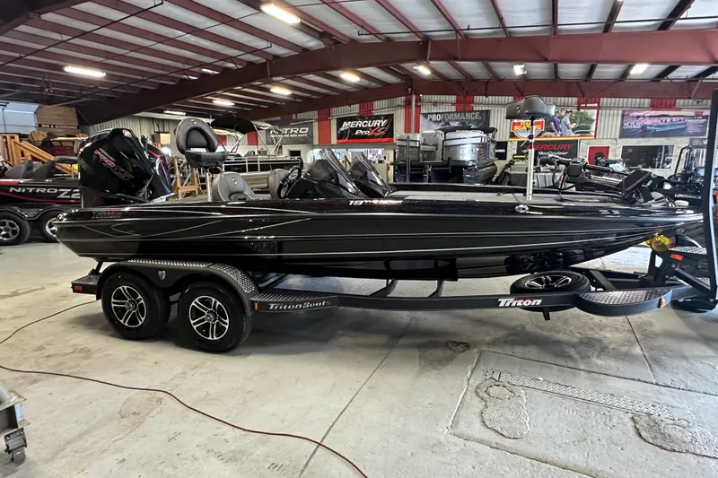 Slide: The Image of 2025 Triton 19 TrX Patriot boat in showroom, sleek black design on trailer. - 3