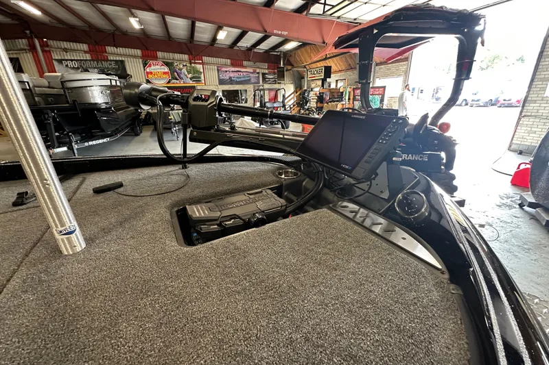 Slide: The Image of 2025 Triton 19 TrX Patriot boat interior with advanced navigation system in a showroom. - 16