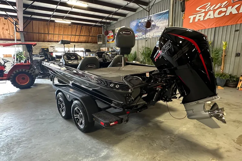 Slide: The Image of 2025 Triton 19 TrX Patriot boat with powerful engine in a showroom setting. - 6
