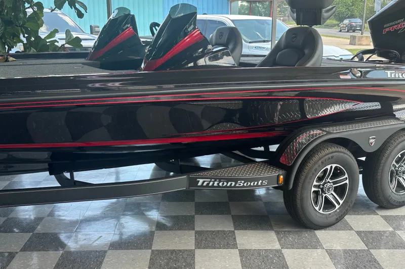 Slide: The Image of 2026 Triton 20XP Patriot boat on display, featuring sleek black and red design. - 127