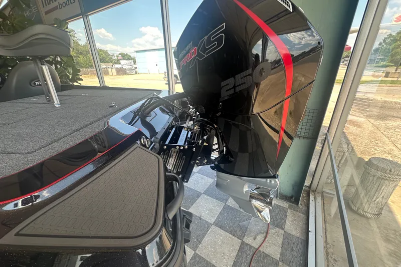 Slide: The Image of 2026 Triton 20XP Patriot boat with powerful 250 Pro XS engine, displayed indoors. - 131
