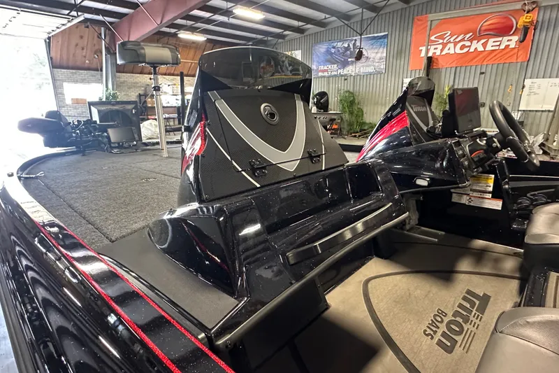 Slide: The Image of 2026 Triton 20XP Patriot boat interior in showroom with Sun Tracker banner. - 14