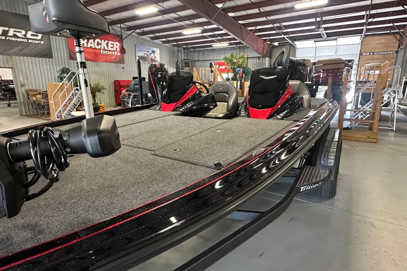 Slide: The Image of 2026 Triton 20XP Patriot fishing boat displayed in a showroom with sleek design. - 12