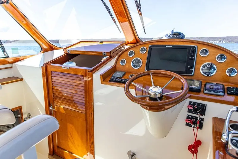 Slide: The Image of Helm of 2014 Hinckley Talaria 34 with wooden steering wheel and navigation instruments. - 11